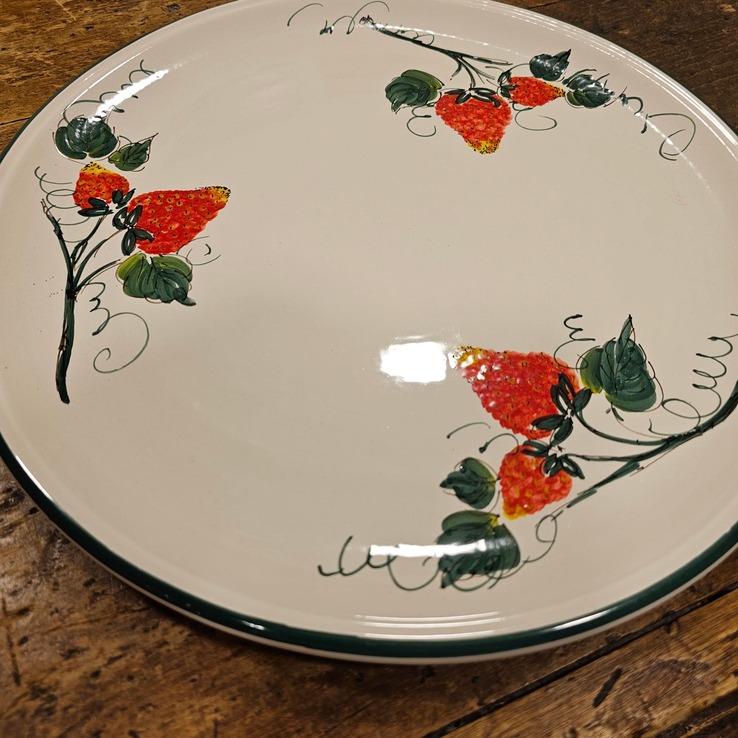 Round ceramic serving plate decorated with strawberries