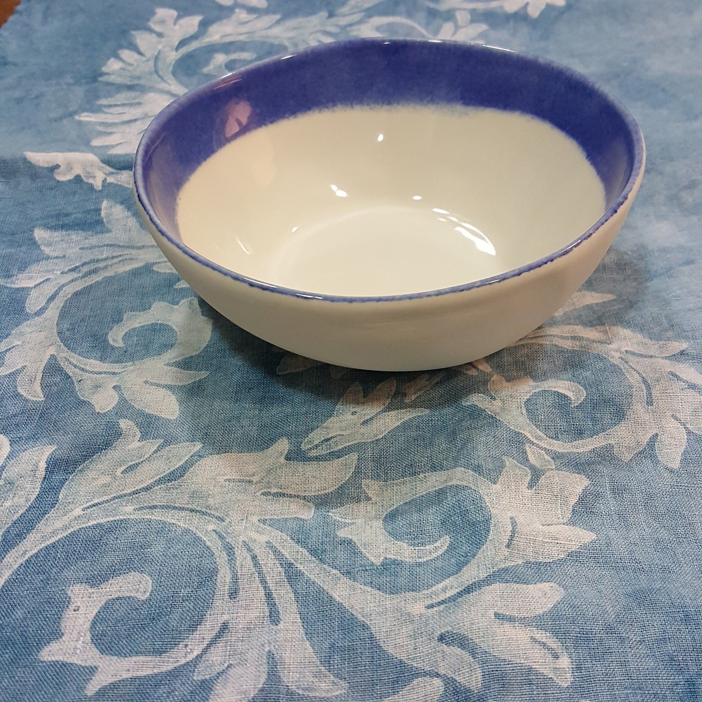 Handmade porcelain bowl with rim.