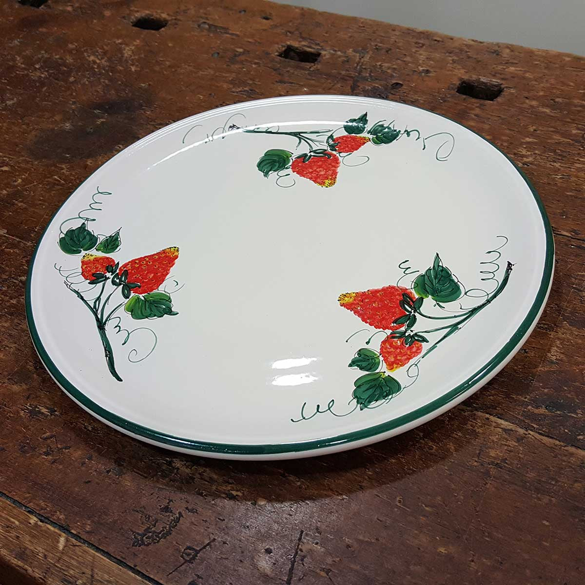 Round ceramic serving plate decorated with strawberries