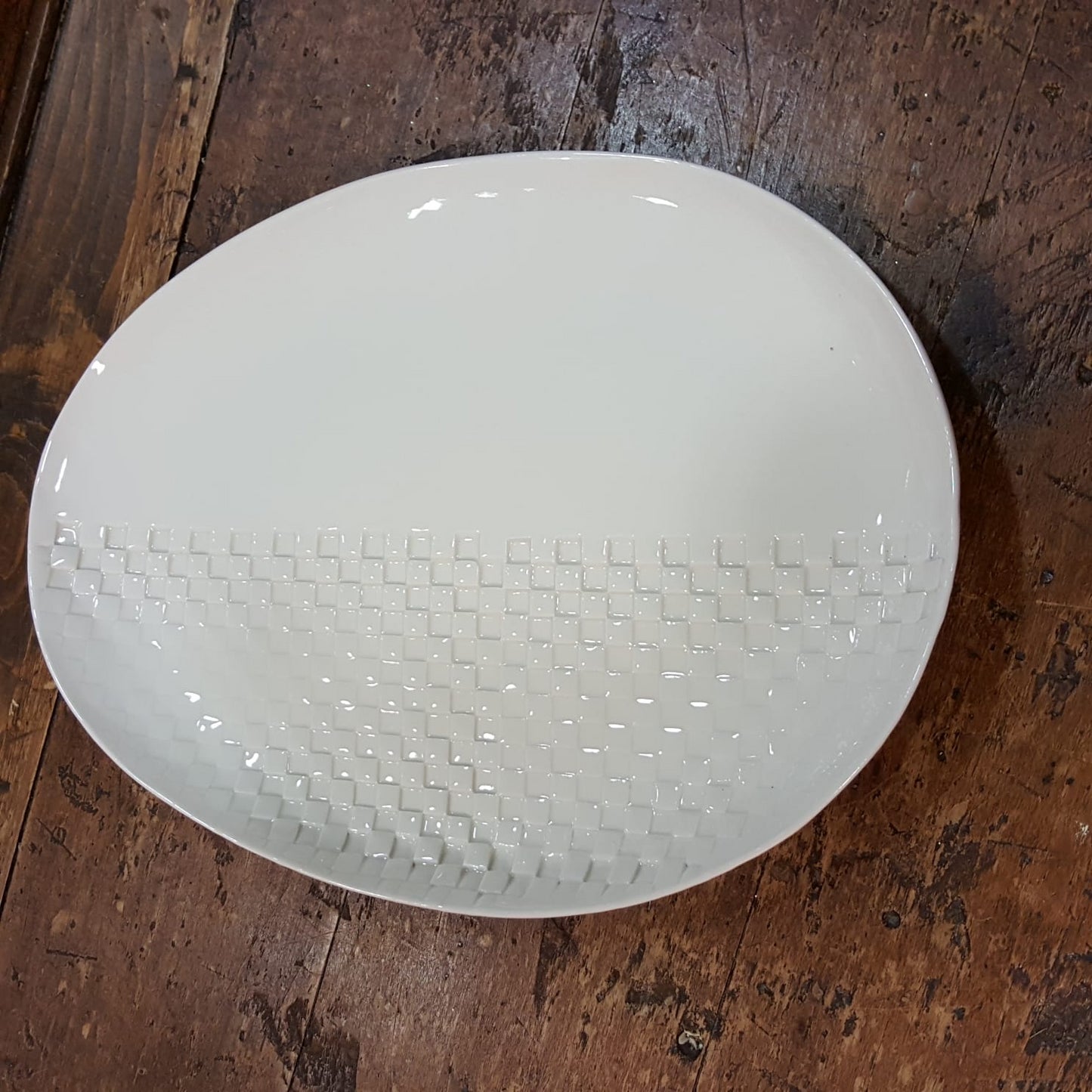 Oval flat plate in white porcelain with checkers imprint