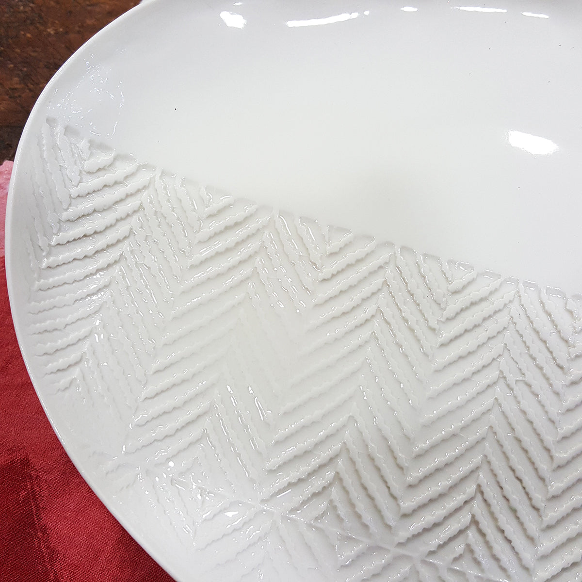 Oval plate in white porcelain with chevron imprint