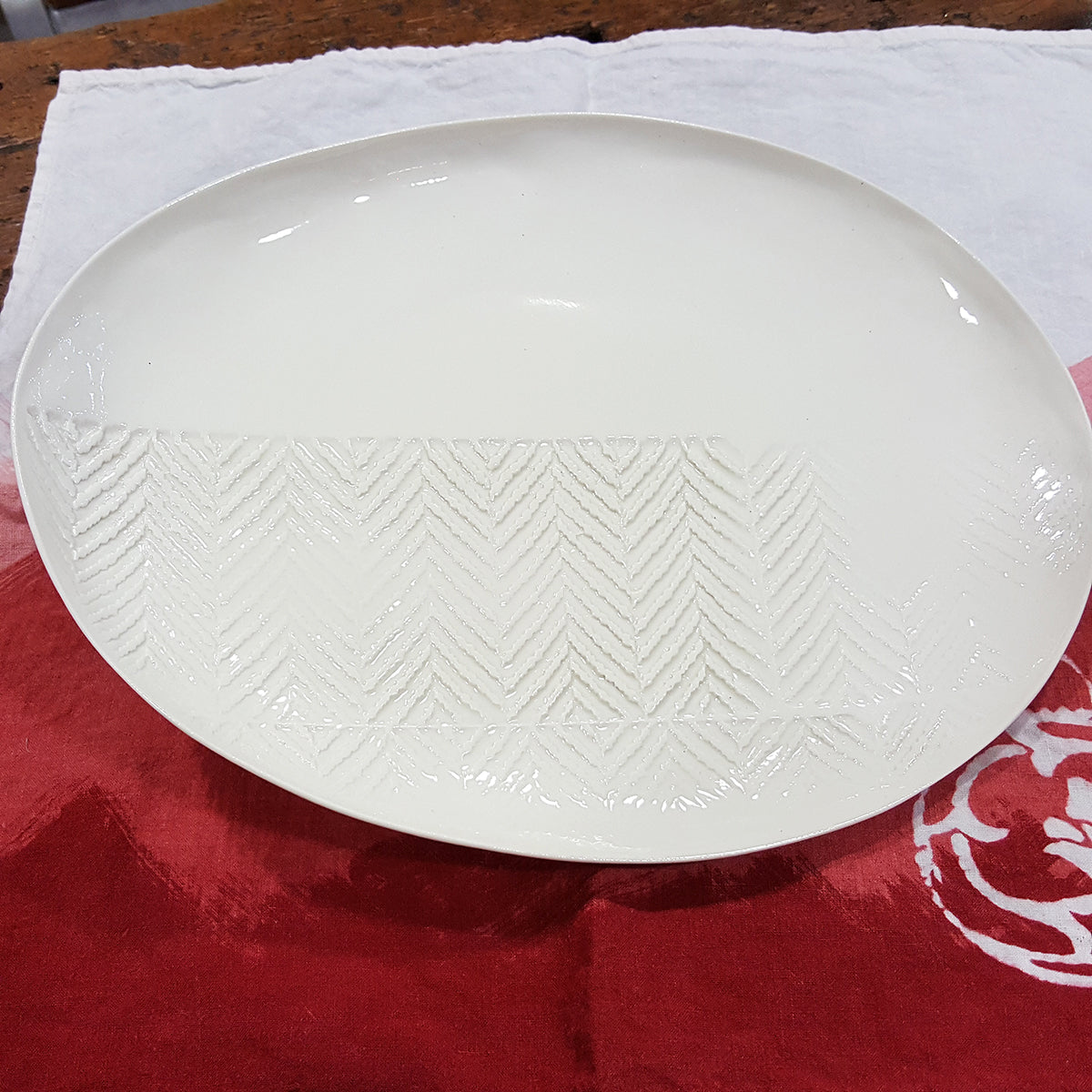 Oval plate in white porcelain with chevron imprint